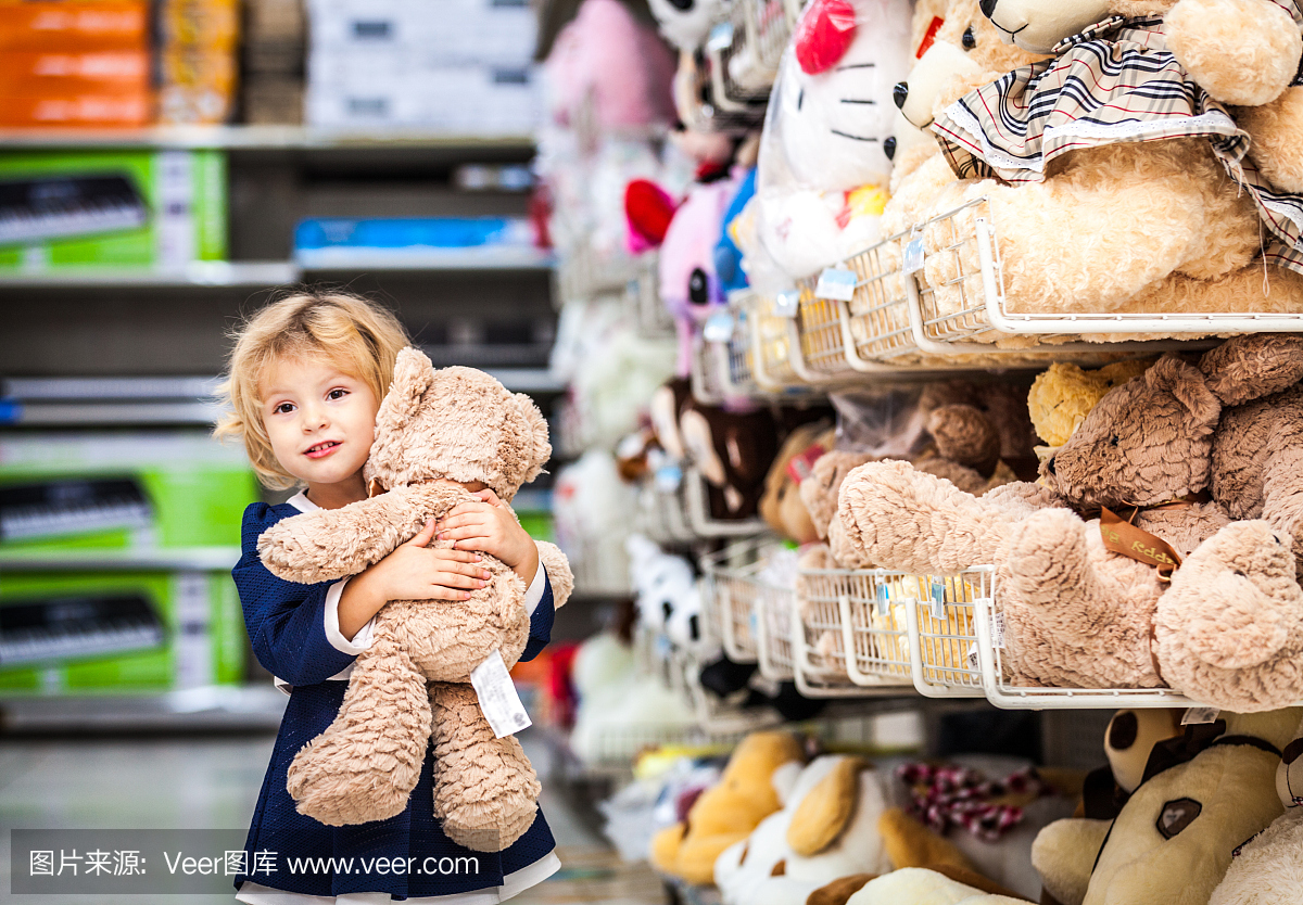 可爱的微笑小女孩和泰迪熊在杂货店